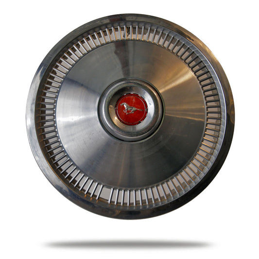 Metallic hubcap with a red center emblem on a white background
